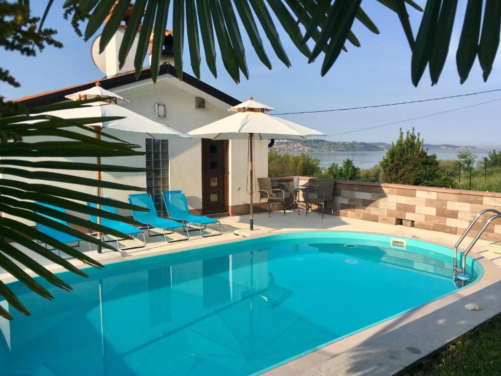 a swimming pool with chairs and an umbrella at Sweet Apartment With Private Pool Lori Ankaran in Ankaran
