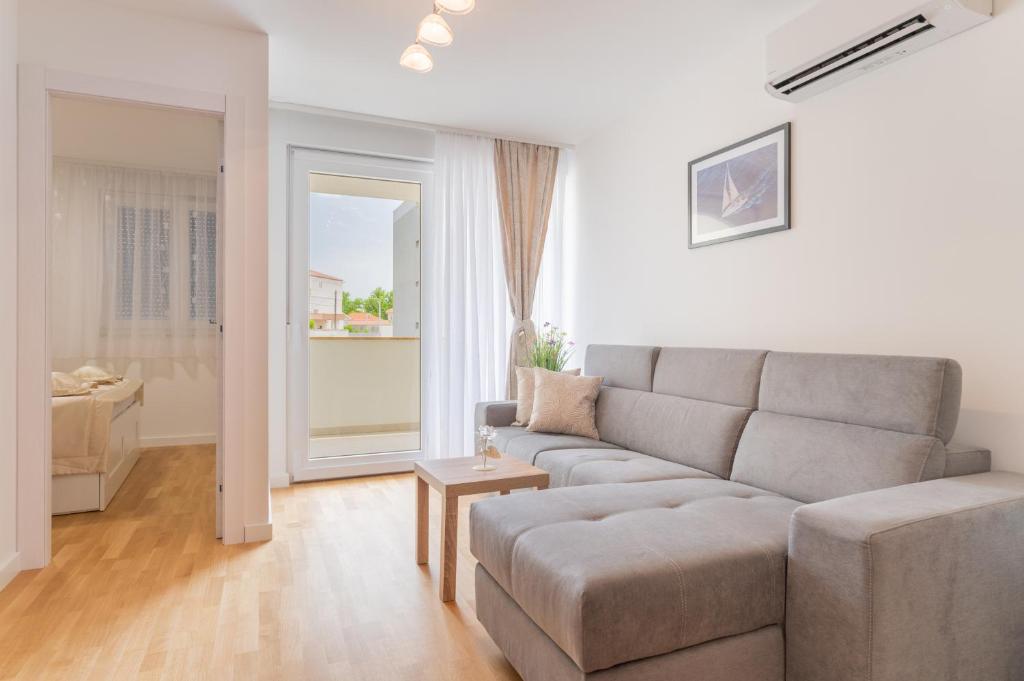 uma sala de estar com um sofá e uma mesa em Luxury Apartment Solinka With Private Parking em Solin