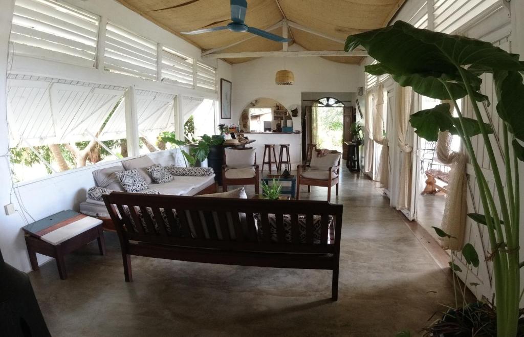 a living room with a couch and a bench at Corto Novo Maison d'hôtes-Camping in Nosy Be