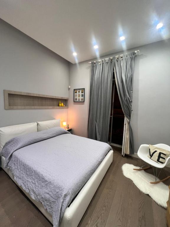 sypialnia z białym łóżkiem i białym krzesłem w obiekcie RaRoom Boutique Home w mieście Torre del Greco