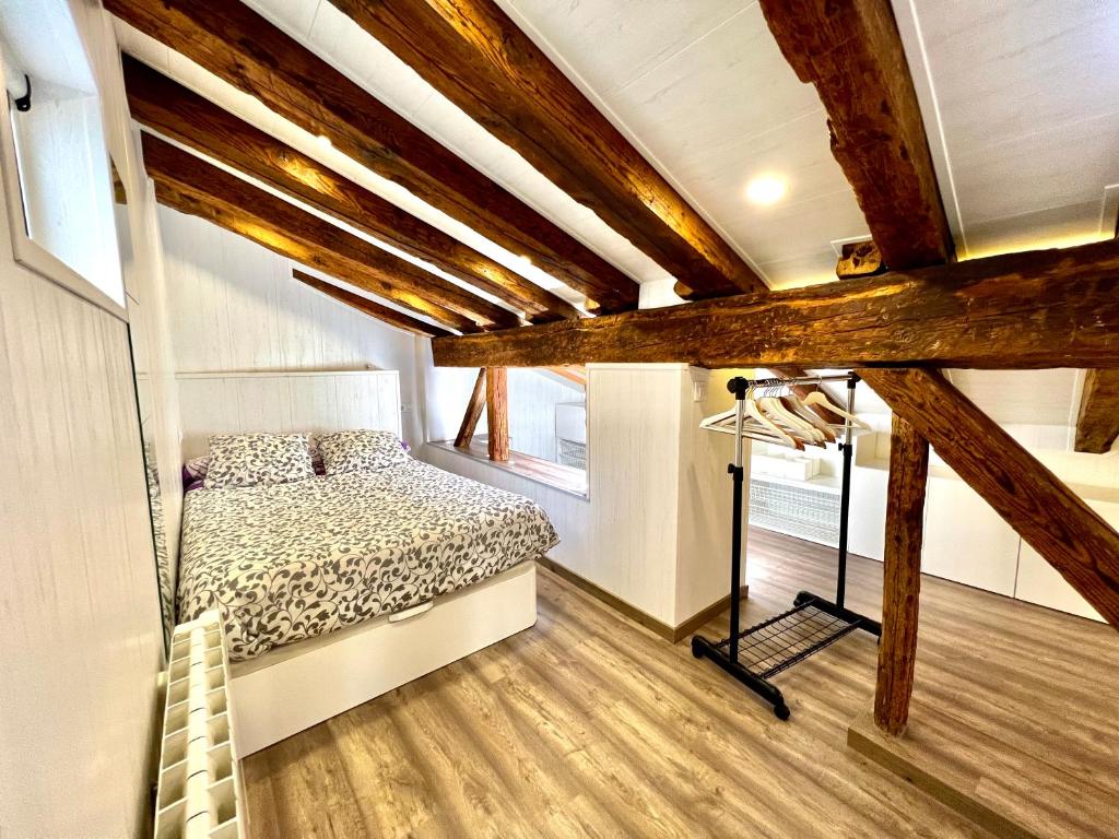 a bedroom with a bed in a room with wooden beams at La buhardilla in Soria