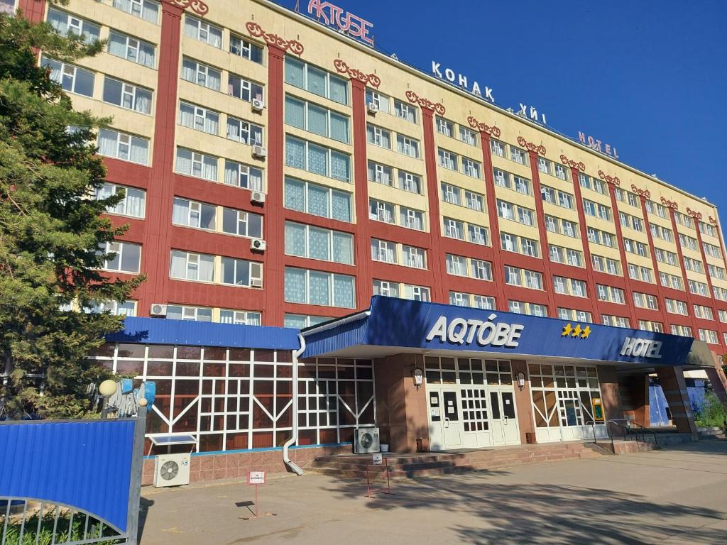 um grande edifício vermelho com um hotel em Aktobe Hotel em Aqtöbe