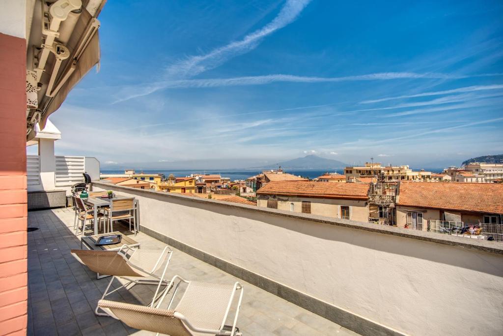 a balcony with chairs and a view of a city at Apartment Baccus in Sorrento