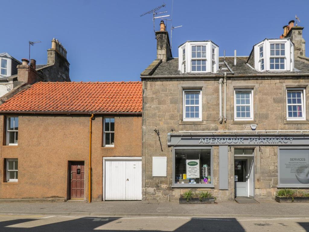 um velho edifício de tijolos com uma loja numa rua em 32 High Street em Burntisland