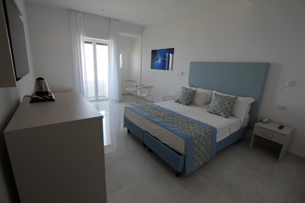 um pequeno quarto com uma cama e uma janela em Hotel Lucia em Castellammare di Stabia
