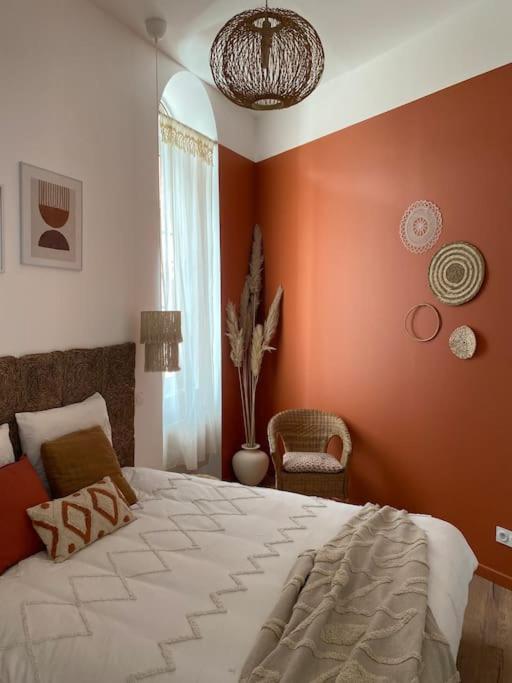 - une chambre avec des murs orange et un grand lit dans l'établissement T2 L'Evasion - TERRASSE - PARKING gratuit - Climatisation, à Bagnères-de-Bigorre