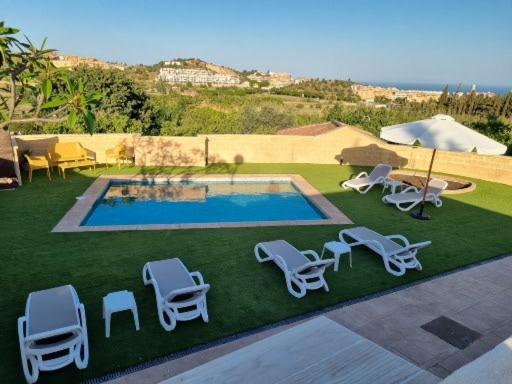 un grupo de tumbonas y una piscina en FINCA VALENZUELA, en Mijas