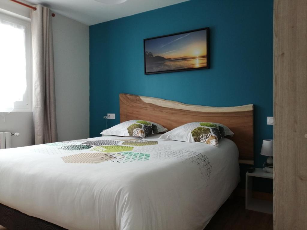 LanvéocにあるHôtel Le Poulmicのベッドルーム1室(青い壁の白いベッド1台付)