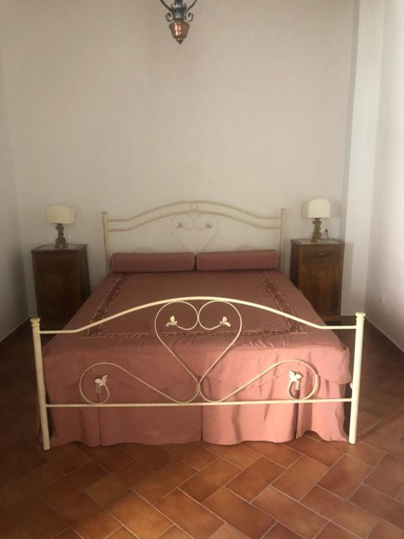1 dormitorio con 1 cama con manta rosa en La casetta in collina, en Reggio Calabria