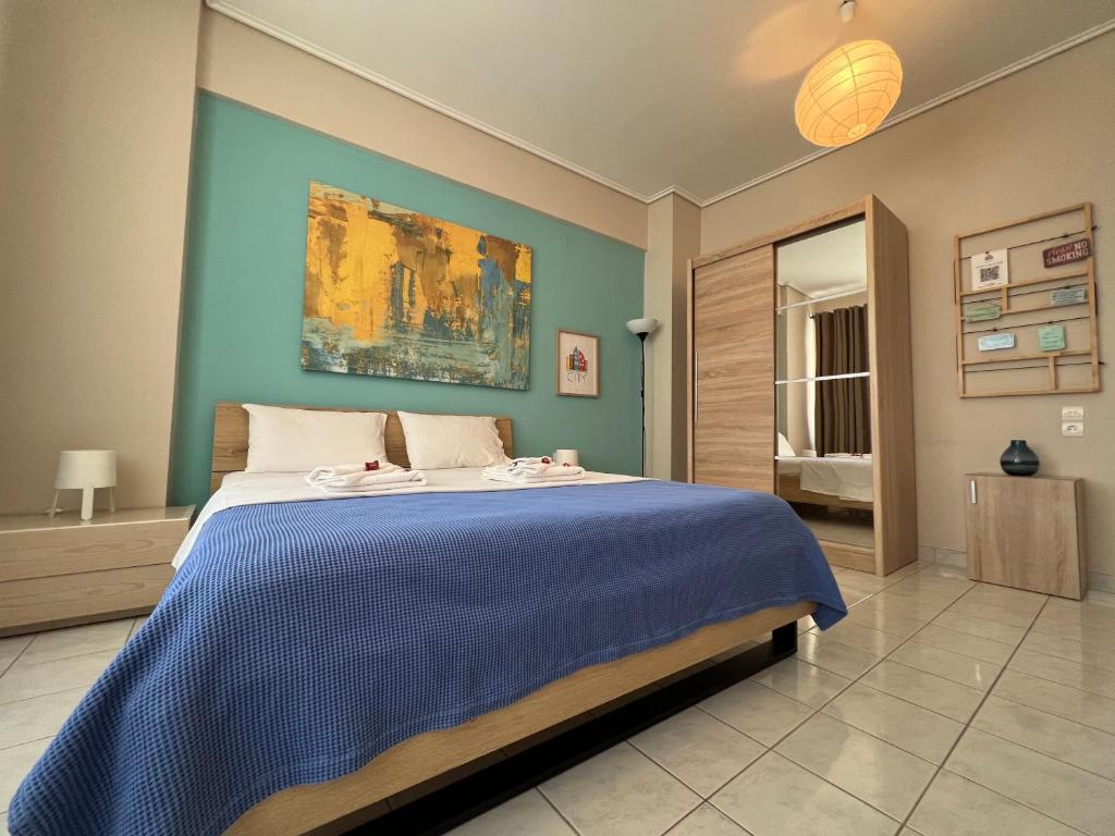 una camera da letto con un grande letto con una coperta blu di City House 1 a Kalamáta
