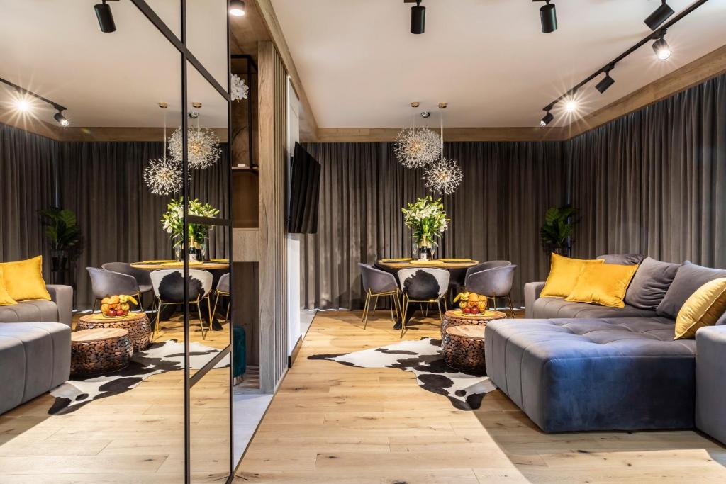 a lobby with couches and a table with chairs at Modrzejewska Residence Zakopane in Zakopane
