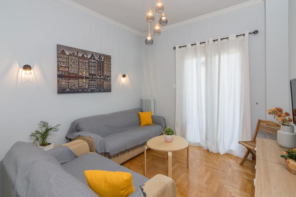 a living room with two couches and a table at Kerameikos Metro Apartment for 4 in Athens