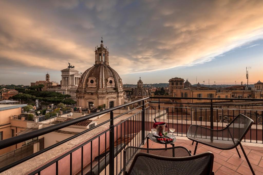 a balcony with chairs and a view of a city at H10 Palazzo Galla in Rome