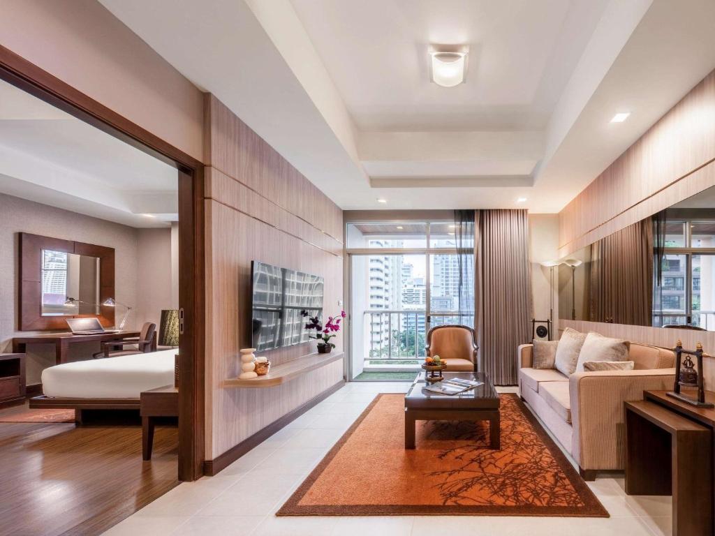 Habitación de hotel con cama y sofá en Grand Mercure Bangkok Asoke Residence, en Bangkok