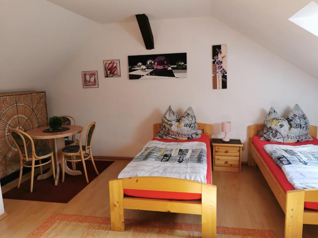 ein Schlafzimmer mit 2 Betten und einem Tisch mit einem Tisch in der Unterkunft Ferienwohnung Anger 1 im 3 Obergeschoß in Annaberg-Buchholz