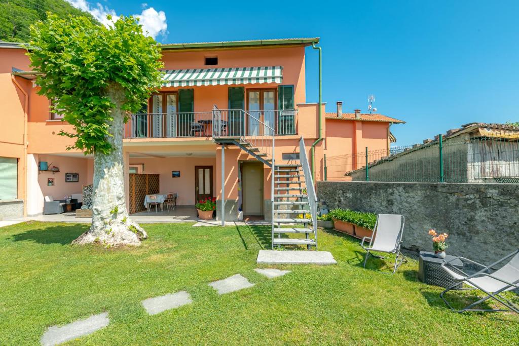 una casa con una escalera y un árbol en el patio en Panorama Lake Como Wi-Fi Parking Free, en Acquaseria