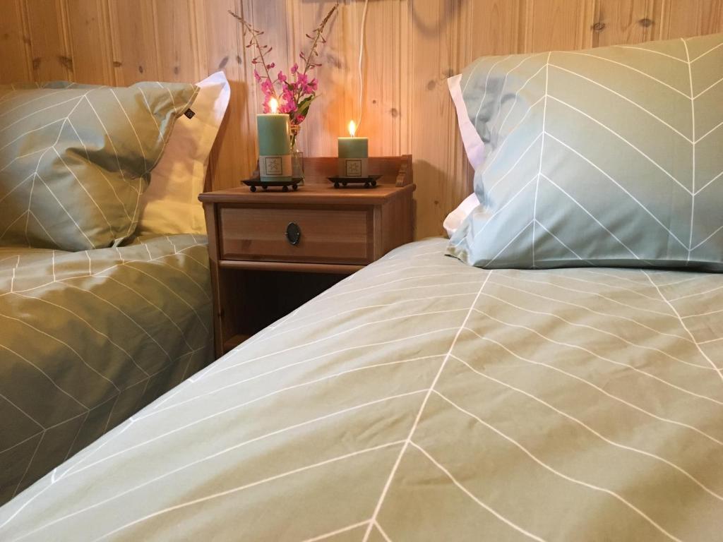 a bedroom with a bed with two candles on a night stand at Reinunga Eco-hytta in Myrdal
