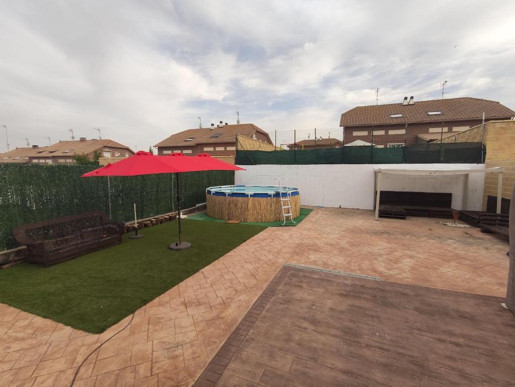 a backyard with a red tent and a lawn at Warner,piscina, aire ac, barbacoa, chillout, 400m patio in Seseña