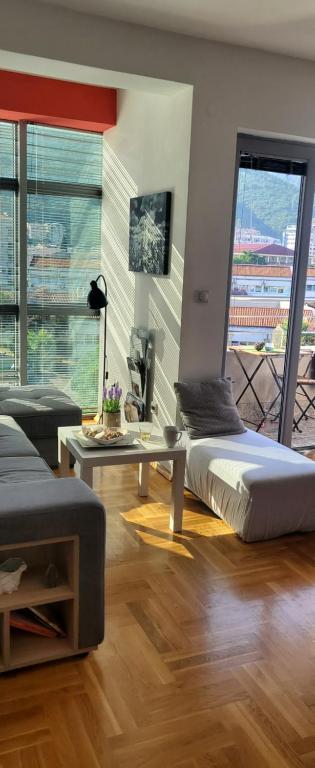 a bedroom with a bed and a table and a balcony at Divine in Budva