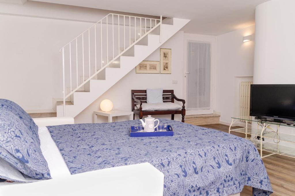 ein Wohnzimmer mit einem Bett und einer Treppe in der Unterkunft [ApuliaLux] Panta Rei Luxury House nel Centro Storico in Altamura