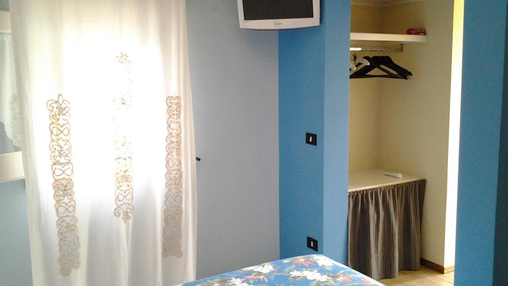 Pokój z łóżkiem i oknem z zasłoną w obiekcie Le Vallonee B&B w mieście Aradeo