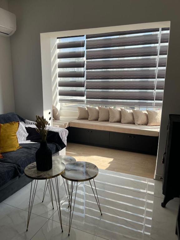 a living room with a window with a couch and a table at Oneiro Napa Suite in Ayia Napa