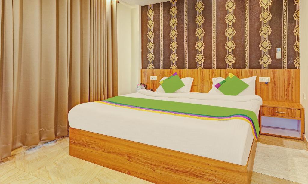 a bedroom with a large white bed with green pillows at Treebo Trend Silver Stallion in Lucknow