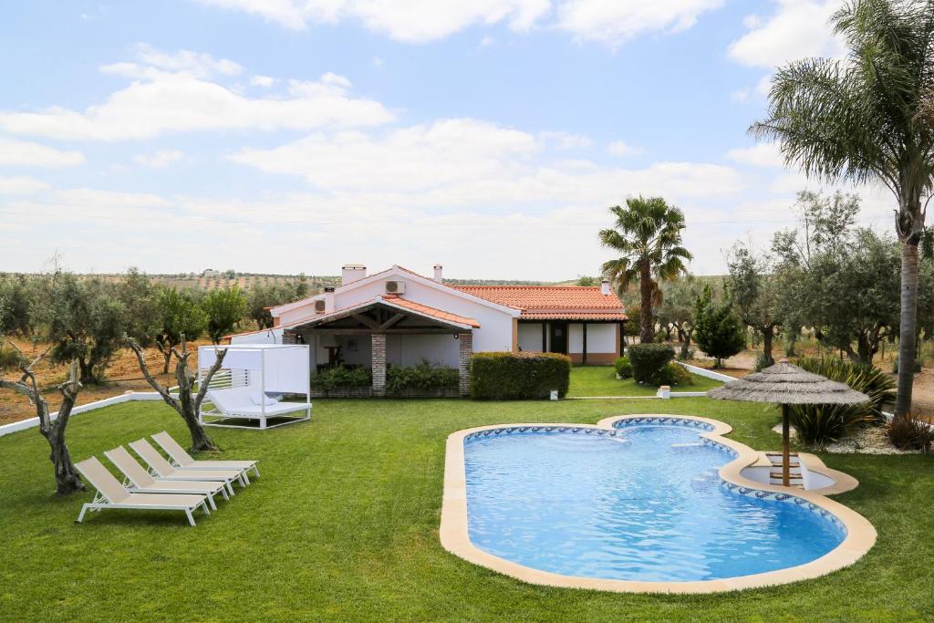 ein Garten mit Swimmingpool und ein Haus in der Unterkunft Monte da Eira Nova in Avis