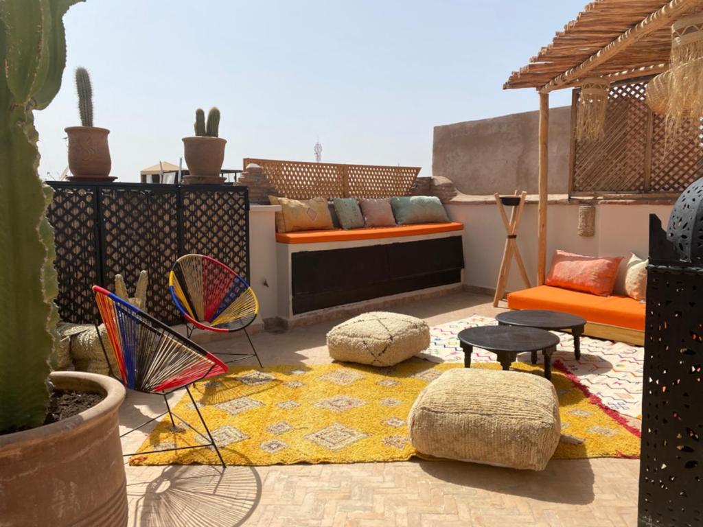 un patio con sofá, sillas y cactus en Riad Gasämbre Touareg, en Marrakech