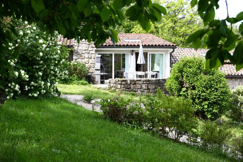 una pequeña casa de piedra con una ventana en un patio en Les Grangeonnes, gîtes nature, piscine, sauna pour accueil familiale ou de groupe, en Saint-Basile