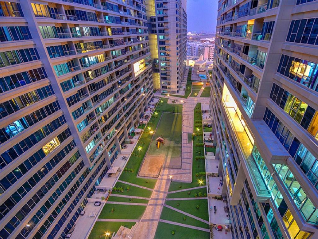 a view of a street between two tall buildings at Octavius Holiday Home, Large 2 Bedroom Apartment near Global Village & Outlet Mall in Dubai