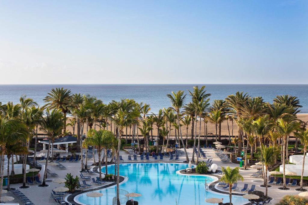 an aerial view of a resort with palm trees and a pool at Hipotels La Geria in Puerto del Carmen