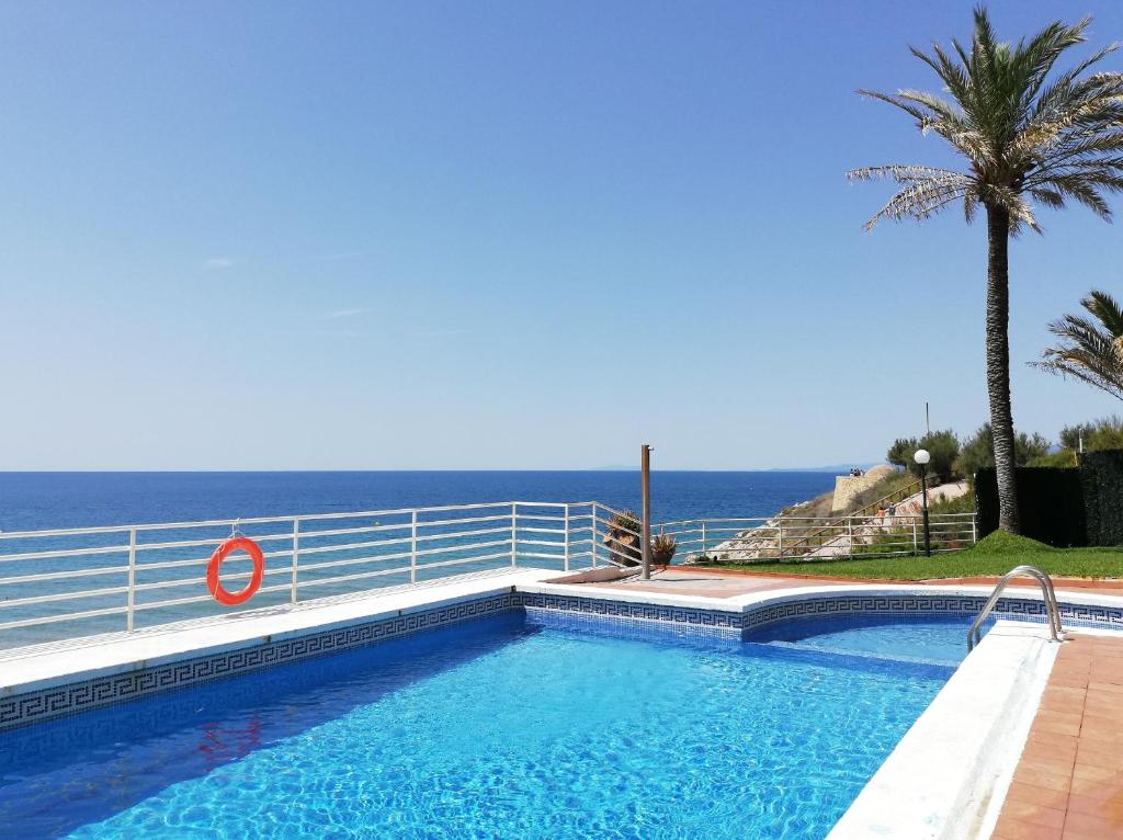 a swimming pool with a view of the ocean at Cala Llenguadets in Salou