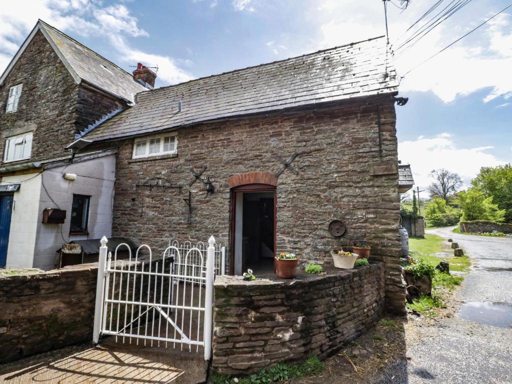 una antigua casa de piedra con una puerta blanca en Bluebell Cottage Farm Stay, en Leominster