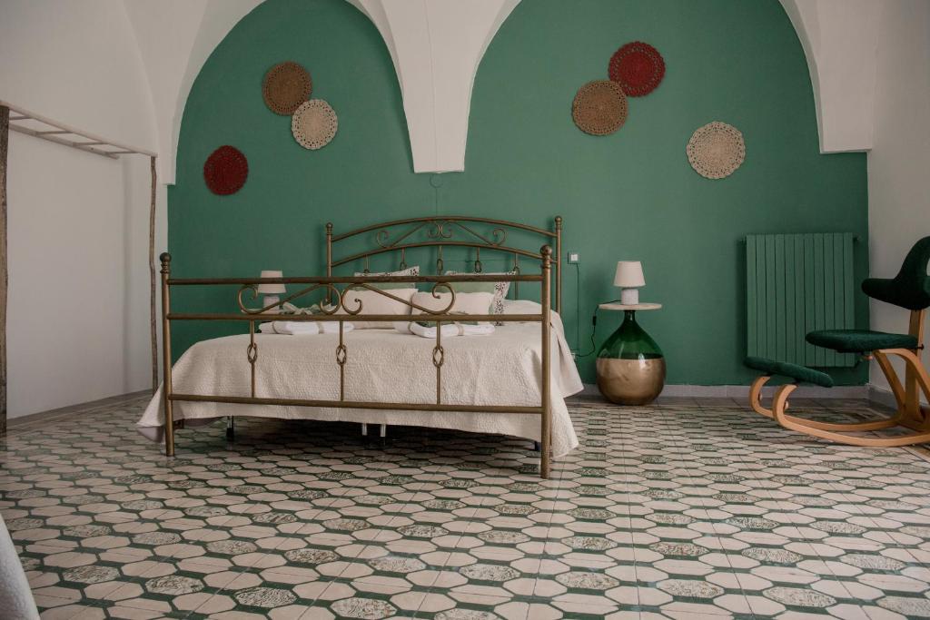 1 dormitorio con 1 cama en una pared verde en Maison Montpellier, en Ceglie Messapica
