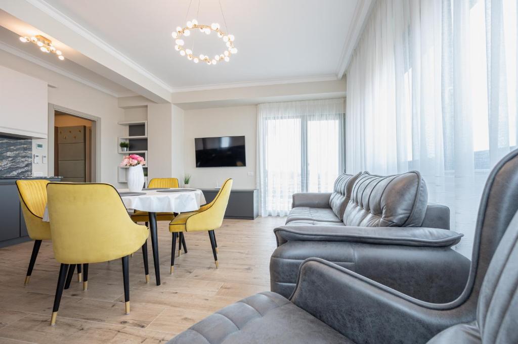 uma sala de estar com um sofá, uma mesa e cadeiras em Alexander Flat em Oradea