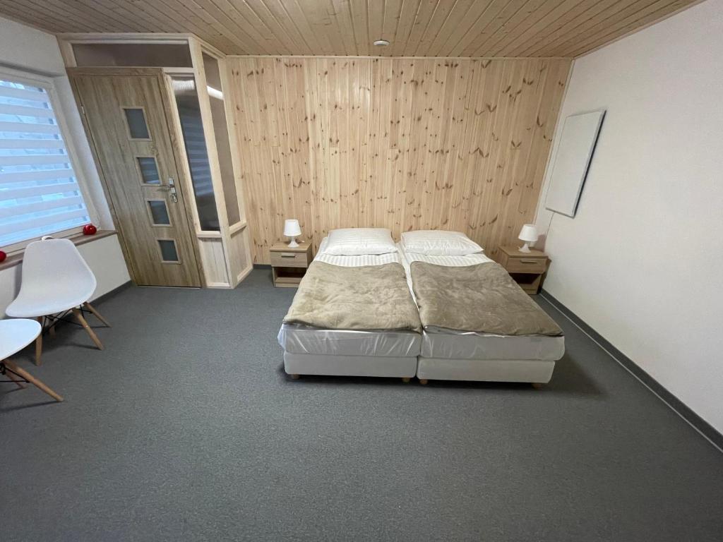 a bedroom with two beds and two tables and chairs at Apart Domek Lądek Zdrój in Lądek-Zdrój