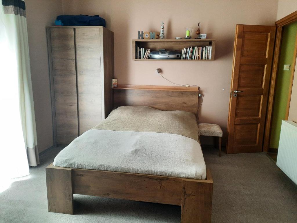 een slaapkamer met een houten bed in een kamer bij Hunyadi utcai garzon in Kaposvár
