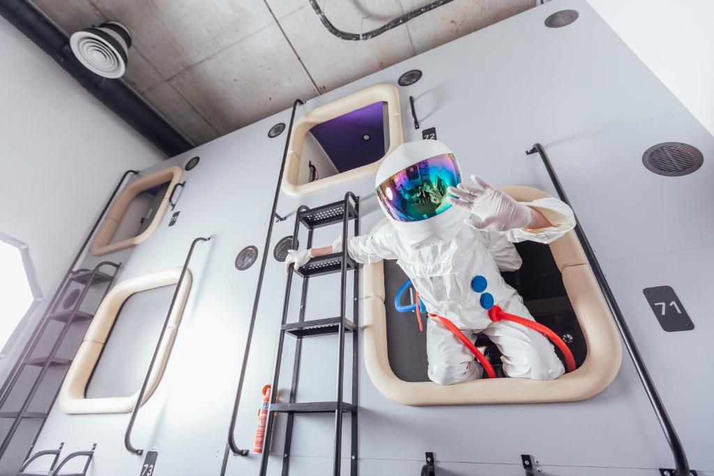 une personne assise sur une échelle dans un bateau dans l'établissement Capsule Hotel Constellation 89, à Lviv