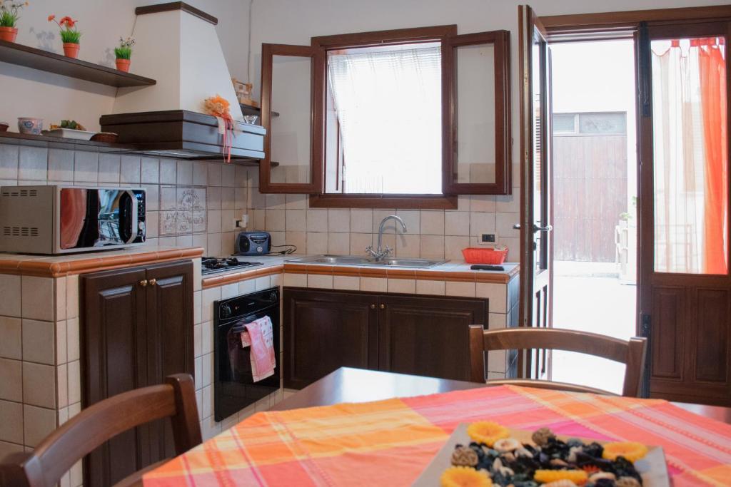 a kitchen with a table and a sink and a stove at La casa di Cecè al centro di San Vito Lo Capo in San Vito lo Capo