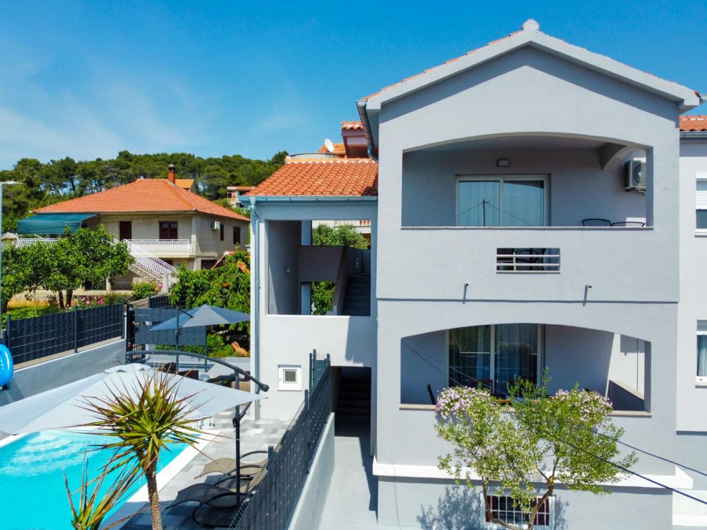 an aerial view of a white house with a swimming pool at Modern apartment with private pool in Bibinje