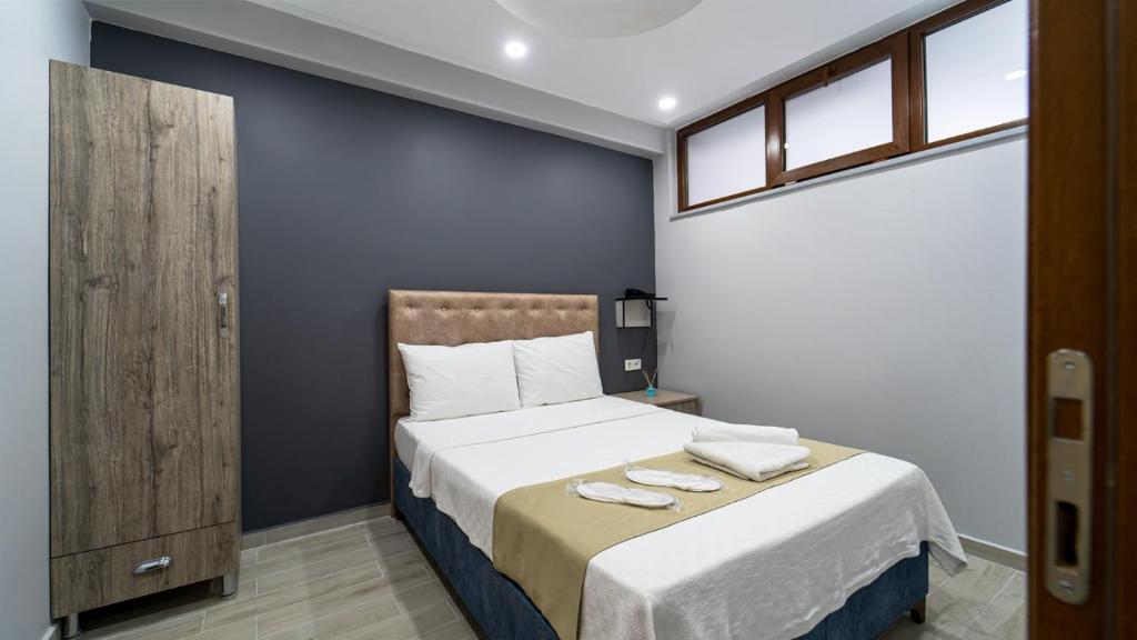 una camera da letto con un letto e due asciugamani di KUMBAĞ ŞEHRİ SARAY APART OTEL a Tekirdağ
