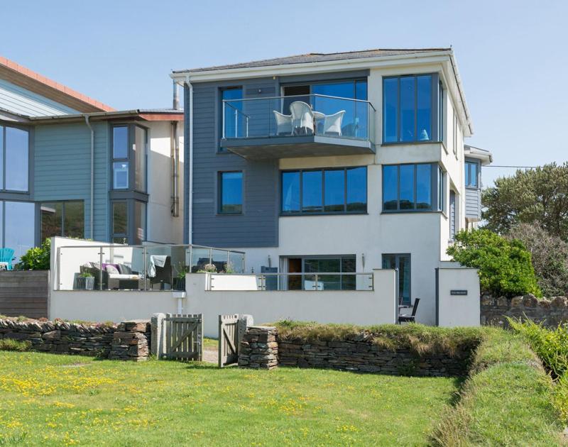 Una casa grande con un perro blanco en un balcón. en Egloskerry, en Wadebridge