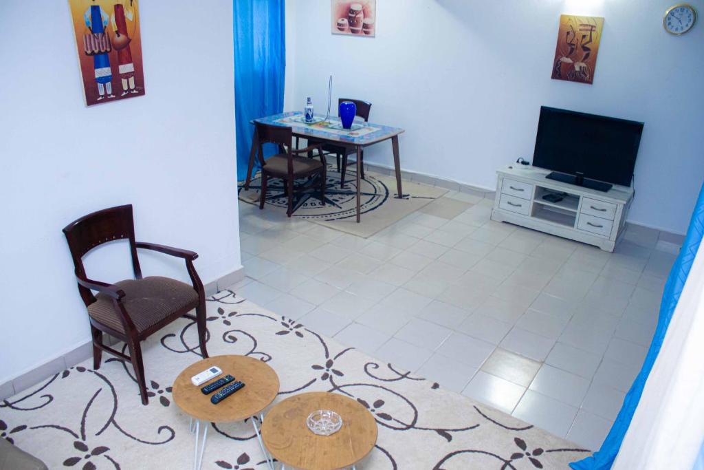 a living room with a table and a television at Super villa avec garage véhicule à 2 mn de la mer in Lomé