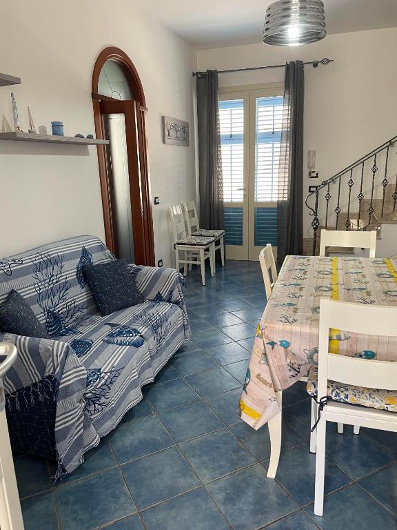 sypialnia z łóżkiem, stołem i krzesłami w obiekcie NEREA - Appartamento fronte mare w mieście San Vito lo Capo