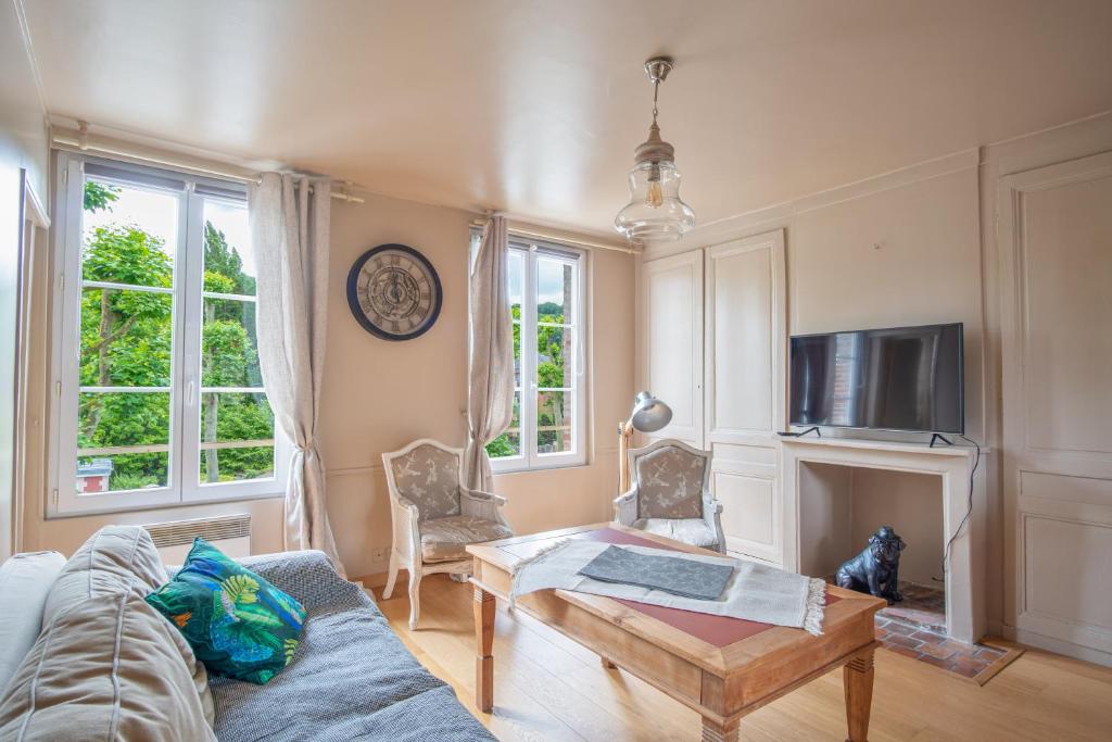 ein Wohnzimmer mit einem Sofa und einem TV in der Unterkunft Un air de vacances in Honfleur