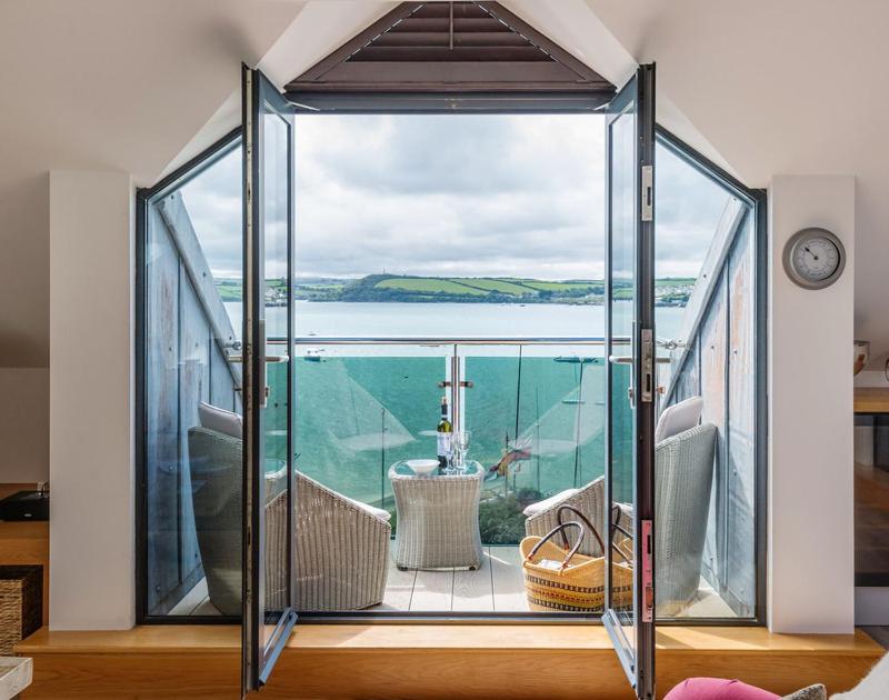 a room with a balcony with a view of the water at Upper Deck in Padstow