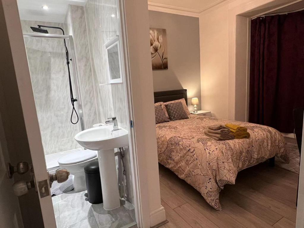 a bedroom with a bed and a sink and a shower at Welsh Homestay in Pembroke Dock