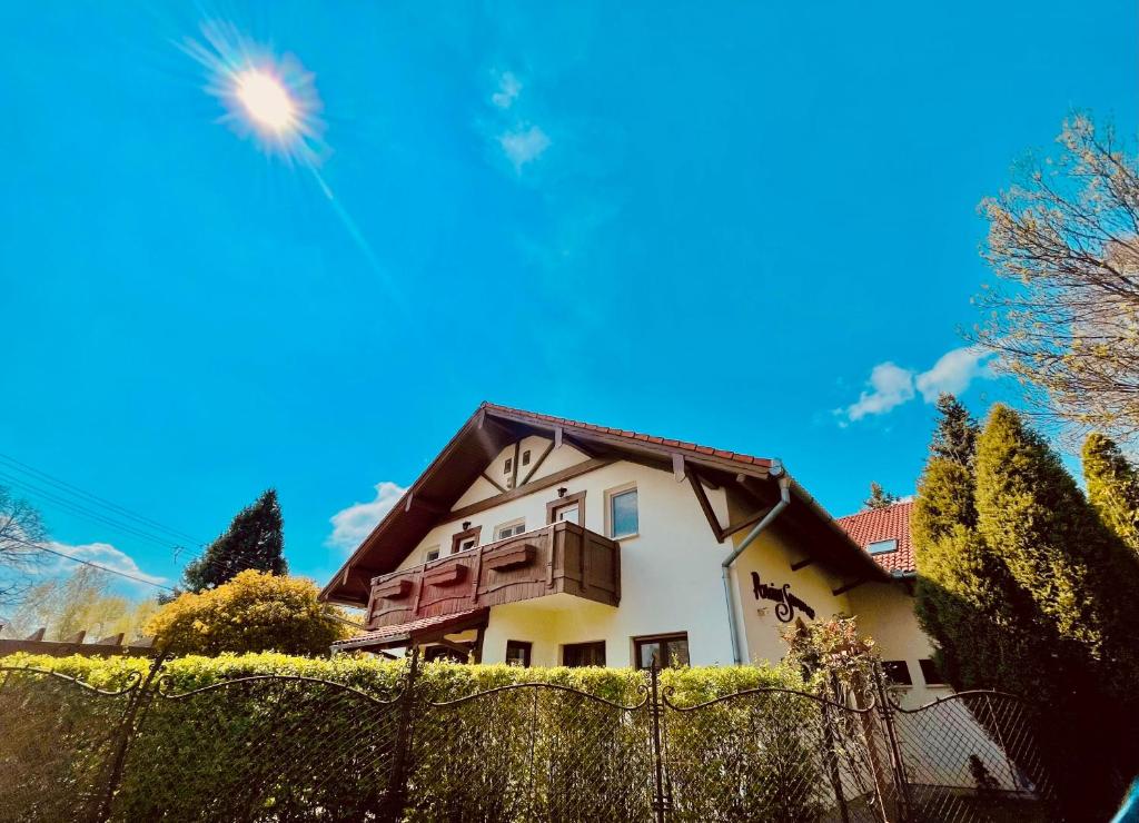 una casa detrás de una valla con un cielo azul en Sommer Panzió en Balatonföldvár