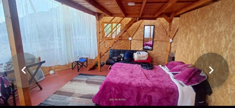 1 dormitorio con 1 cama grande con manta morada en GLAMPING Aldea Muisca, en Tota